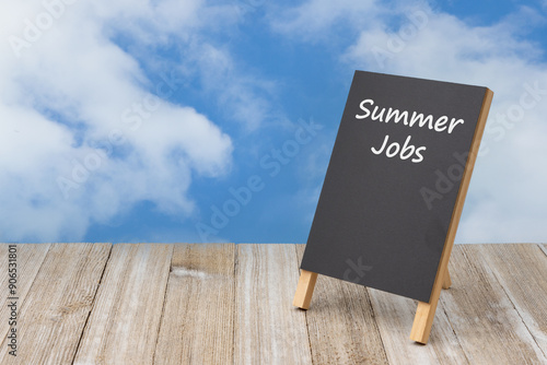 Fotografie Ad for summer jobs on a chalkboard easel on a table with sky