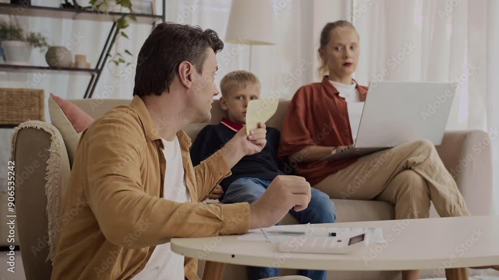 Medium shot of Caucasian man telling his wife about high utility bill at home Medium shot of Caucasian man telling his wife about high utility bill at home