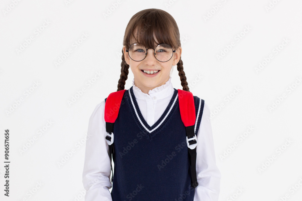 Indoor picture of young good-looking teenage girl isolated on white background in school uniform, wearing glasses and red backpack, feeling relaxed and positive, willing to walk