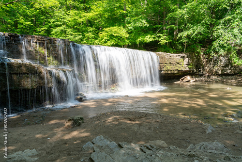 A beautiful view of a waterfall hidden away in a lush and green forest.