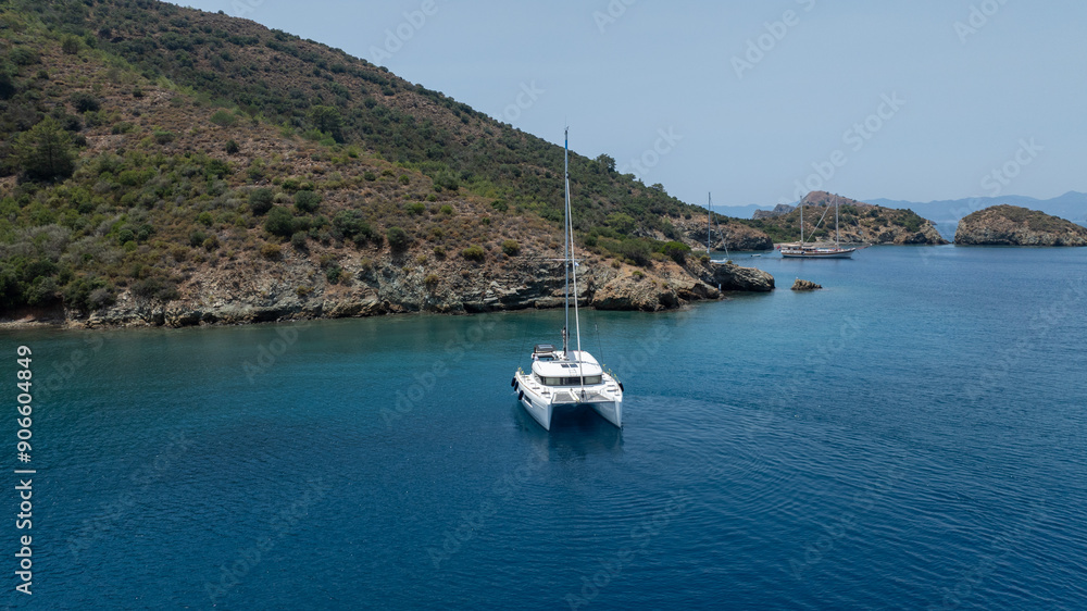 Stunning drone shot of a catamaran navigating the open sea Stunning drone shot of a catamaran navigating the open sea