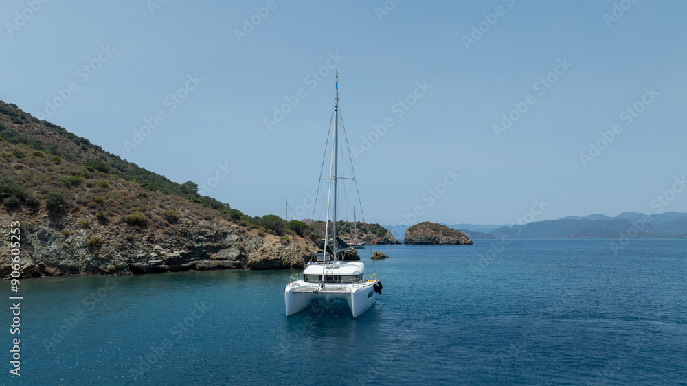 Stunning drone shot of a catamaran navigating the open sea. Stunning drone shot of a catamaran navigating the open sea.