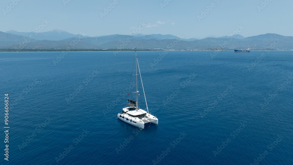 Stunning drone shot of a catamaran navigating the open sea Stunning drone shot of a catamaran navigating the open sea