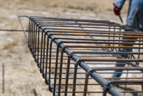 Foto A worker uses steel tying wire to fasten steel rods to reinforcement bars