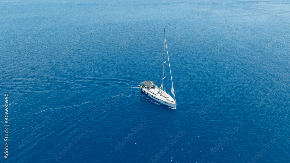 Stunning drone shot of a sailing boat gliding under the clear blue sky Stunning drone shot of a sailing boat gliding under the clear blue sky