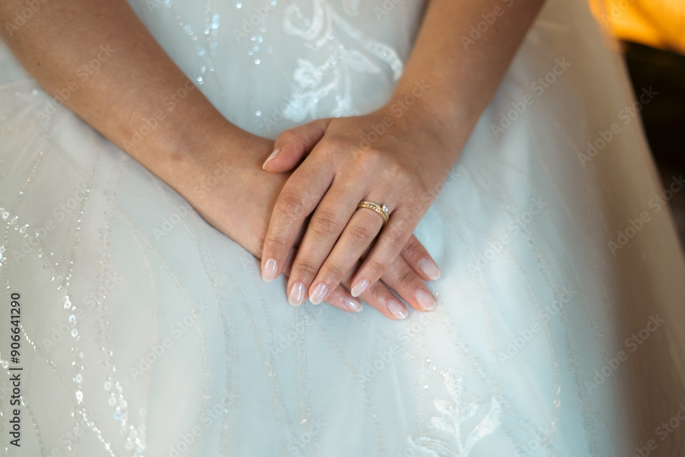 Romantic Wedding Touch: Bride’s Hands with a Timeless Engagement Ring and Subtle Manicure, Captured Over a Classic Bridal Gown Romantic Wedding Touch: Bride’s Hands with a Timeless Engagement Ring and Subtle Manicure, Captured Over a Classic Bridal Gown