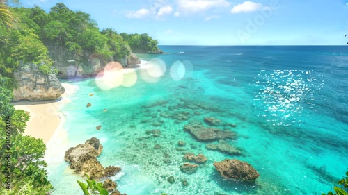 Tropical beach with clear blue water, white sand, and lush green foliage.