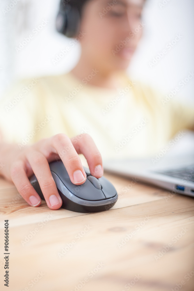 Close-up of the hand of a young student manipulating the mouse of his laptop. Out of focus background. Close-up of the hand of a young student manipulating the mouse of his laptop. Out of focus background.