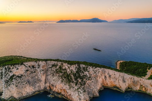 Lighthouse on the cliff. Seascape of Cape Lefkatas with old lighthouse on Lefkada island, Greece. Beautiful views of azure sea water and nature with cliffs photo