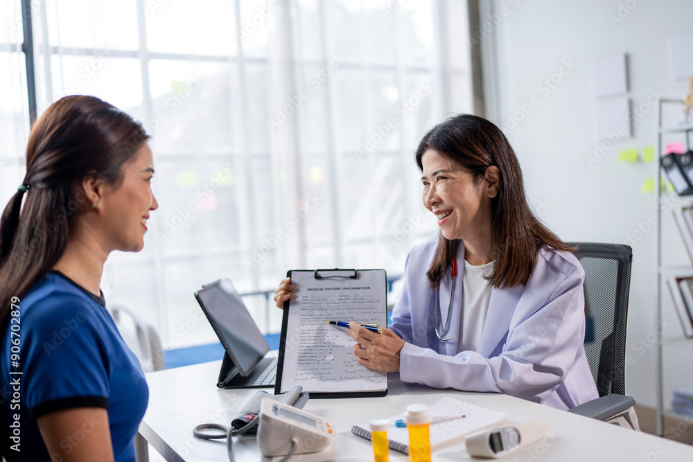 A woman is sitting at a desk with a doctor A woman is sitting at a desk with a doctor