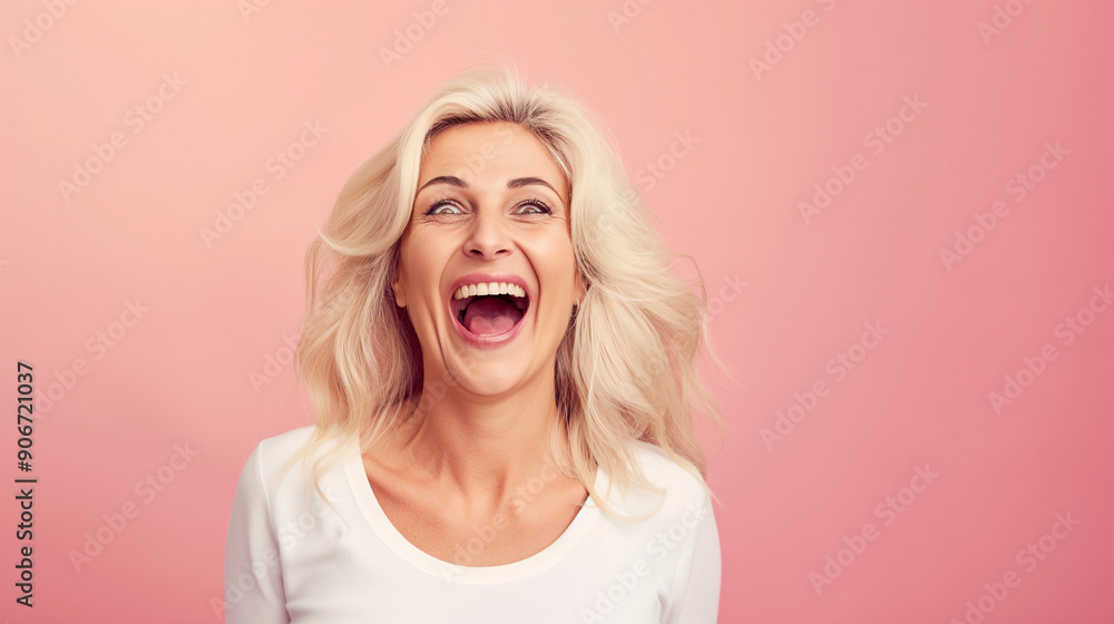 A happy surprised senior woman with open mouth and joy isolated on a pink background. A happy surprised senior woman with open mouth and joy isolated on a pink background.
