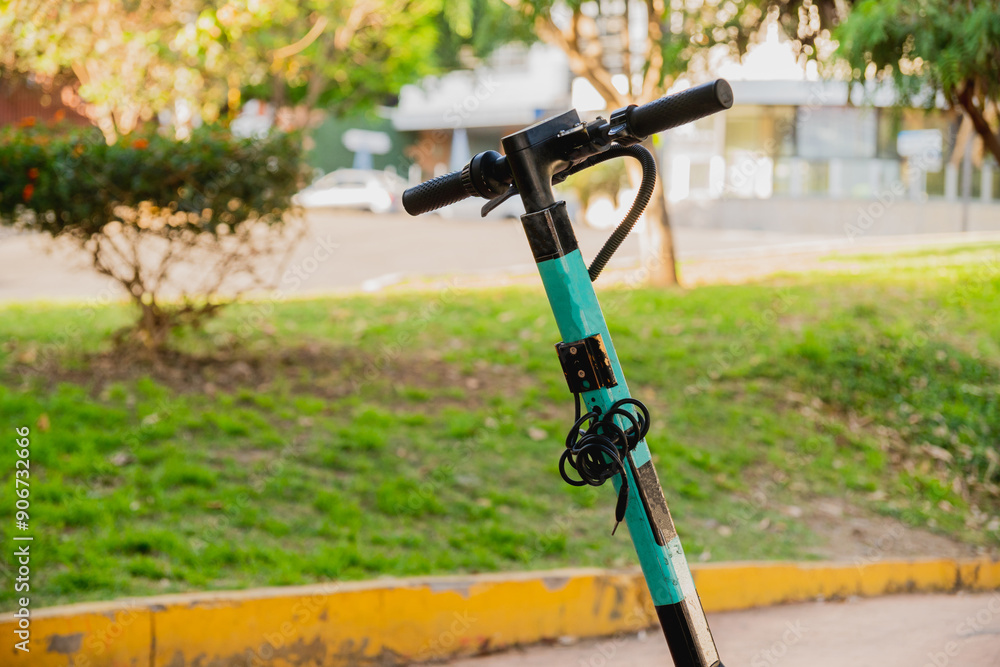 Close up on the handlebars of a scooter, in a public park Close up on the handlebars of a scooter, in a public park