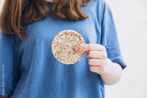 Whole grain cake, buckwheat cake, rice cake in the hands of a girl. photo