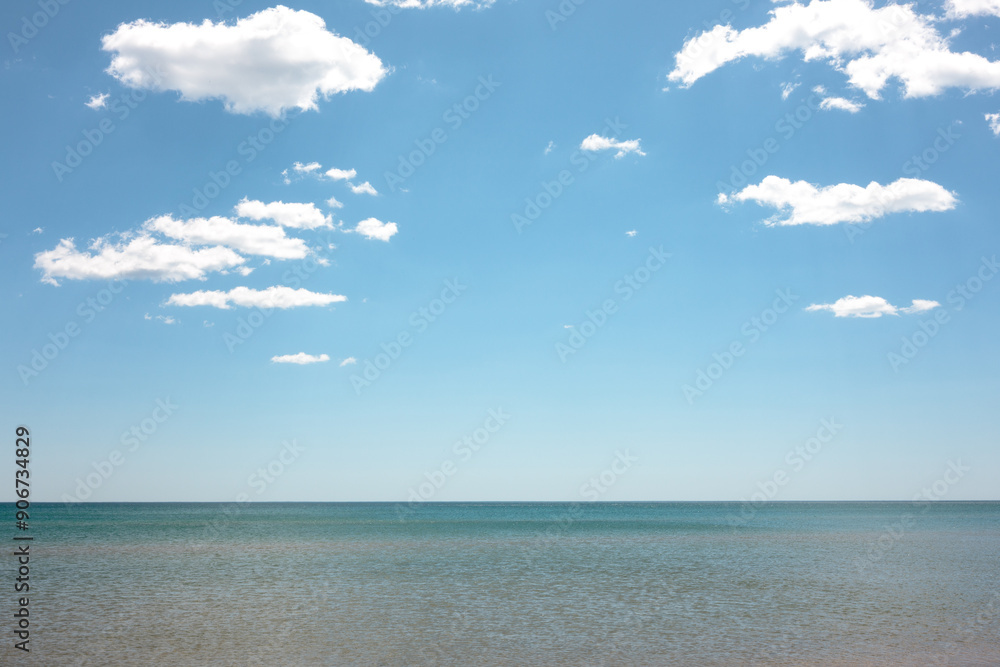 Very calm water, a few clouds and sunshine over Lake Michigan just off the coast of Kohler-Andrae State Park, Sheboygan, Wisconsin in mid-May Very calm water, a few clouds and sunshine over Lake Michigan just off the coast of Kohler-Andrae State Park, Sheboygan, Wisconsin in mid-May