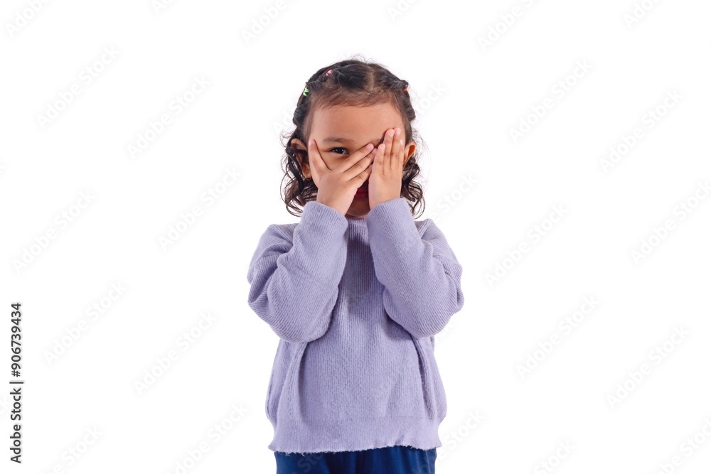 A little Asian girl covers her face with her hands and peeks between her fingers A little Asian girl covers her face with her hands and peeks between her fingers