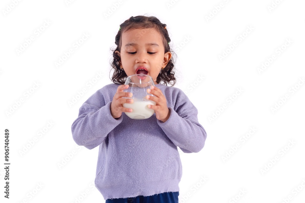Excited little Asian girl drinking a glass of milk, on a white background Excited little Asian girl drinking a glass of milk, on a white background