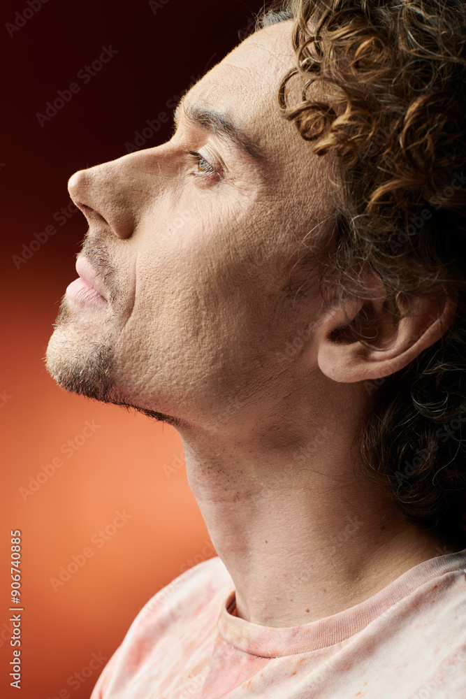 Fototapeta premium A man displays deep emotion while posing against a colorful background.