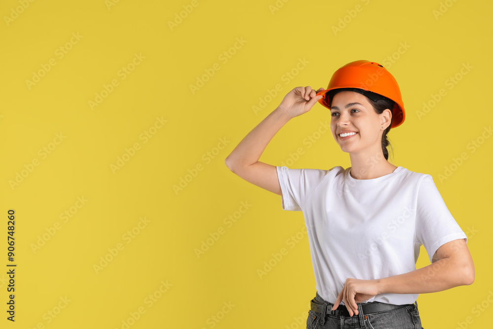 Engineer in hard hat on yellow background, space for text Engineer in hard hat on yellow background, space for text