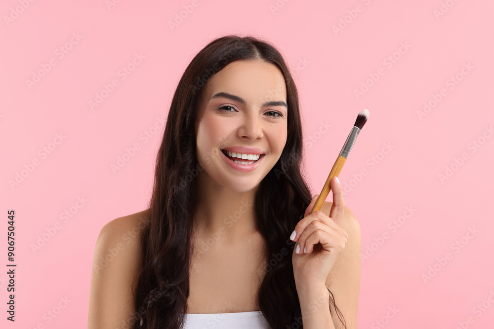 Beautiful makeup. Smiling woman with brush on pink background Beautiful makeup. Smiling woman with brush on pink background