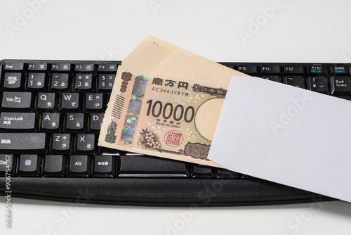 日本円の一万円札で新紙幣の封筒入りの10万円とキーボード photo