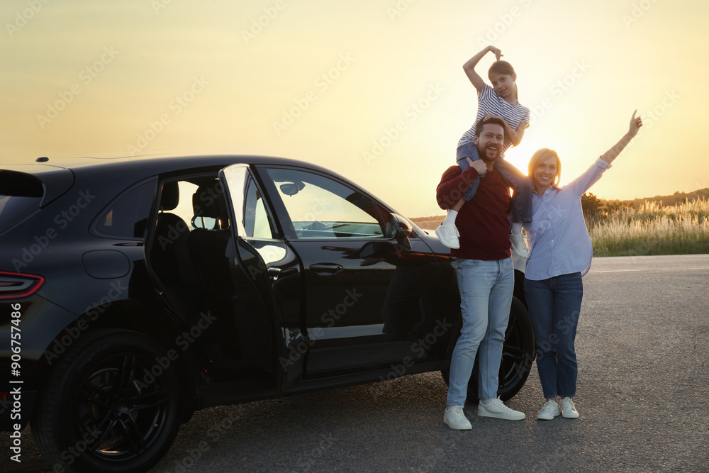Happy parents and their daughter near car outdoors Happy parents and their daughter near car outdoors