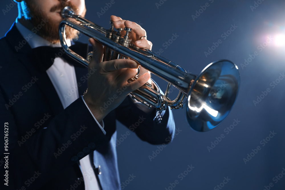 Obraz premium Professional musician playing trumpet on dark background, closeup