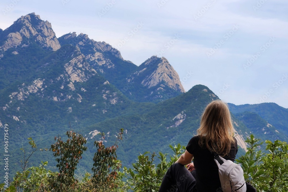 Naklejka premium The girl looks at the mountain tops.