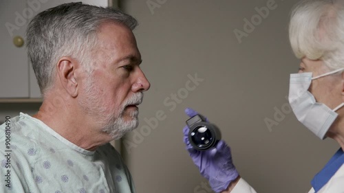 closeup senior man getting a spot on his nose examined  by a dermatologist