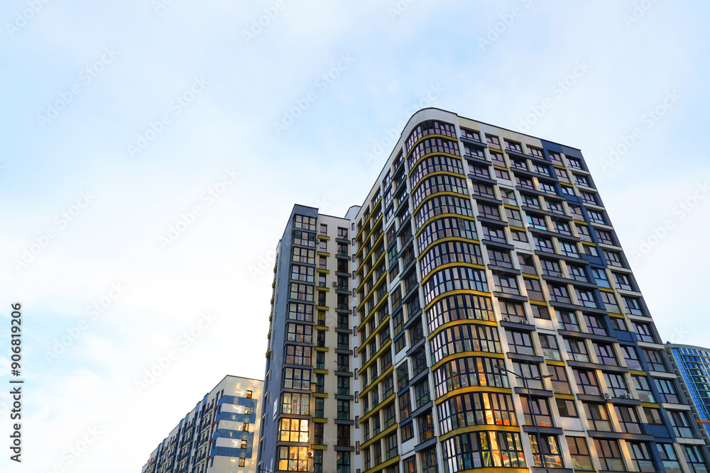 Fototapeta premium Facade building. Modern building and houses against blue sky. Colorful buildings with glass windows, balconies. Buildings architecture. Skyline Skyscrapers. Urban Residential building exterior.