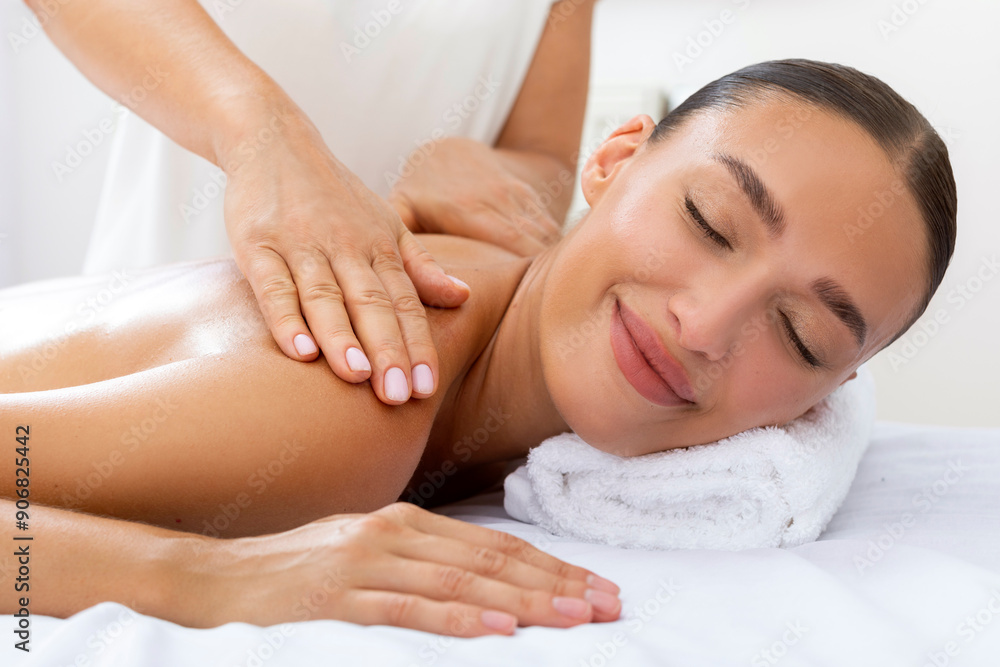 Smiling lady getting shoulders massage by professional masseur, lying with closed eyes in luxury beauty salon Smiling lady getting shoulders massage by professional masseur, lying with closed eyes in luxury beauty salon
