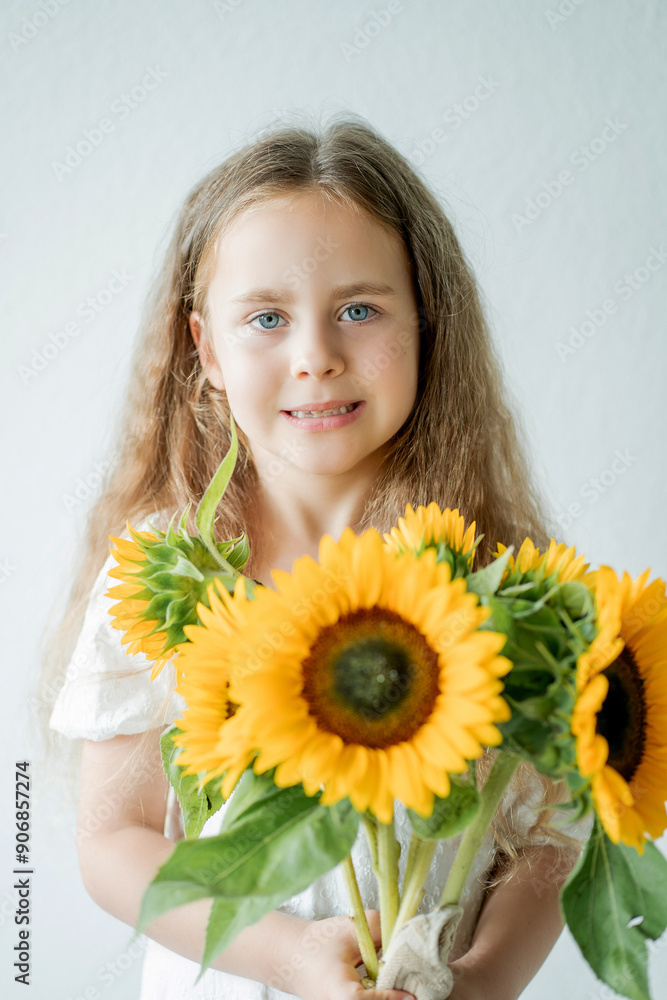 Portrait of cute little curly girl with blue eyes with bouquet of sunflowers in home decor. Portrait of cute little curly girl with blue eyes with bouquet of sunflowers in home decor.