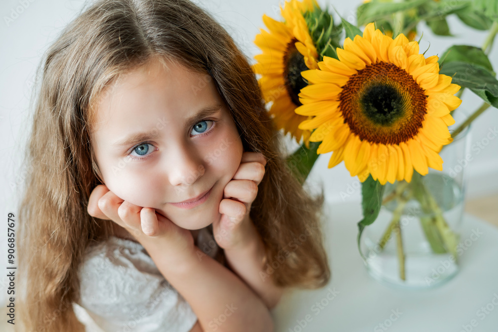 Portrait of cute little curly girl with blue eyes with bouquet of sunflowers in home decor. Portrait of cute little curly girl with blue eyes with bouquet of sunflowers in home decor.