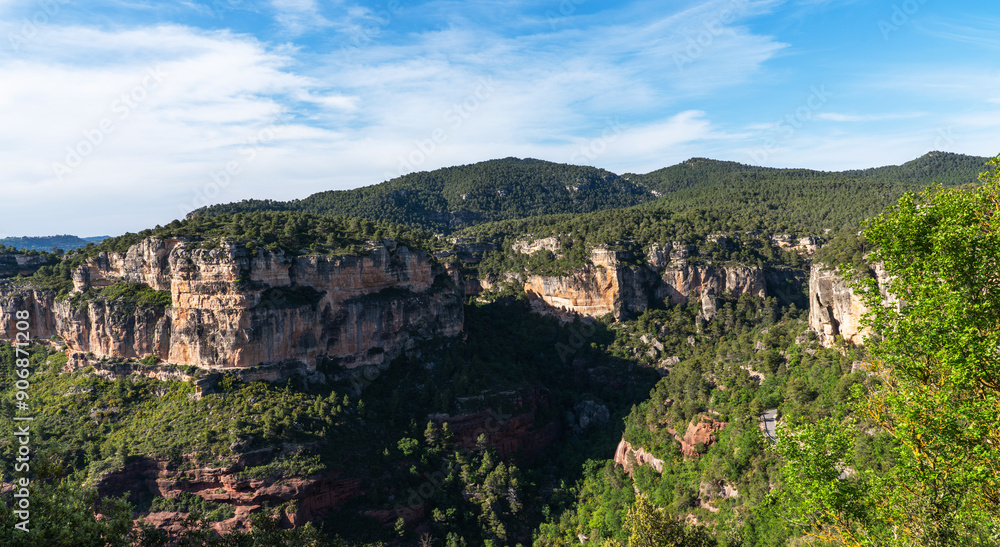 Majestic cliffs rise like ancient citadels, crowned with verdant forest, standing guard over the valley's lush carpet of trees under a serene sky. Majestic cliffs rise like ancient citadels, crowned with verdant forest, standing guard over the valley's lush carpet of trees under a serene sky.