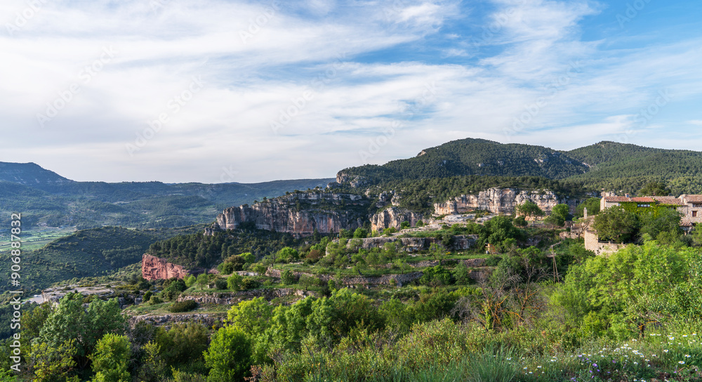 Verdant foliage frames the rugged beauty of stratified cliffs, with a backdrop of rolling hills extending into the horizon under a gentle sky. Verdant foliage frames the rugged beauty of stratified cliffs, with a backdrop of rolling hills extending into the horizon under a gentle sky.
