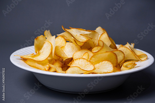 Pile of Cassava Chips on a plate on a dark gray background. Traditional Indonesian snack 