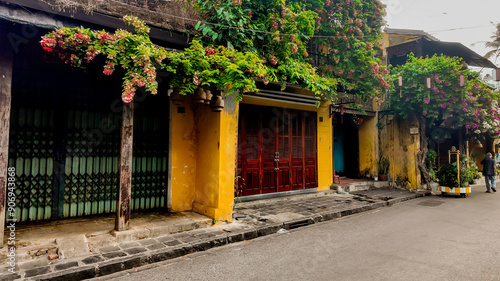 Charming street scene with colorful buildings and flowering plants in Hoi An, Vietnam, celebrating Tet Lunar New Year photo