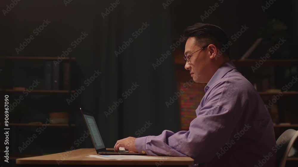 Young asian businessman with glasses use laptop typing on keyboard. Working at night time. Serious look on screen. 360 degree. Moving around Young asian businessman with glasses use laptop typing on keyboard. Working at night time. Serious look on screen. 360 degree. Moving around