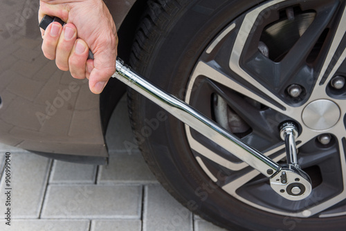 Man pulling in tyre with a torque moment wrench