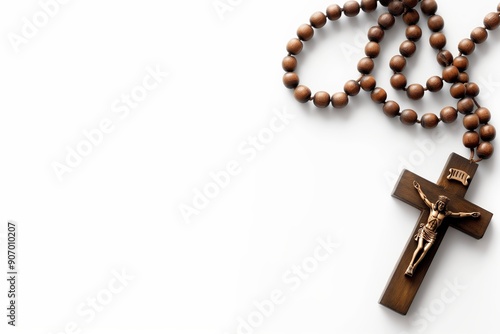 Wooden cross with rosary beads and crucifix on a white background with an empty copy space for text