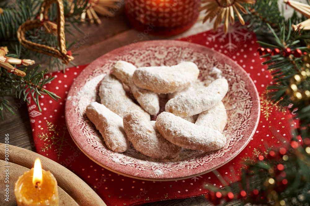 Homemade Christmas cookies called Kipferl or vanilla crescents coated in sugar on a vintage plate with decorated spruce tree branches Homemade Christmas cookies called Kipferl or vanilla crescents coated in sugar on a vintage plate with decorated spruce tree branches