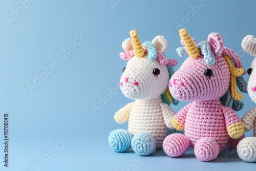 Crochet amigurumi handmade stuffed soft colored unicorn toys with rainbow man on the blue background. Handwork, hobby. Craft diy newborn