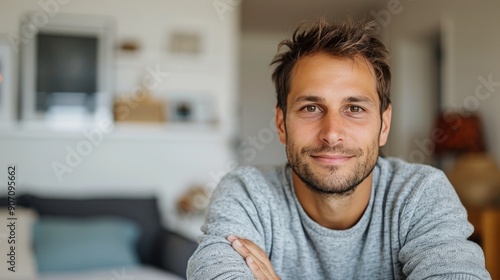 Smiling Man in Gray Sweater Sitting Comfortably in Cozy Indoor Space
