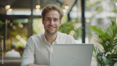Portrait of happy young businessman working on his laptop