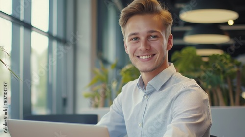 Portrait of happy young businessman working on his laptop