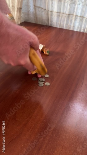 Coins spilling out of a clay jug piggy bank