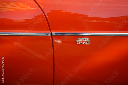 Coupé mit Heckklappe in Orange aus dem England der Sechzigerjahre und Siebzigerjahre mit Chrom und Union Jack beim Oldtimertreffen Golden Oldies in Wettenberg Krofdorf-Gleiberg bei Gießen in Hessen photo