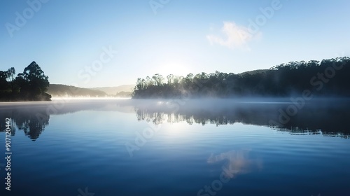 Early Morning Mist Over Tranquil Lake Surrounded by Lush Greenery in Serene Landscape