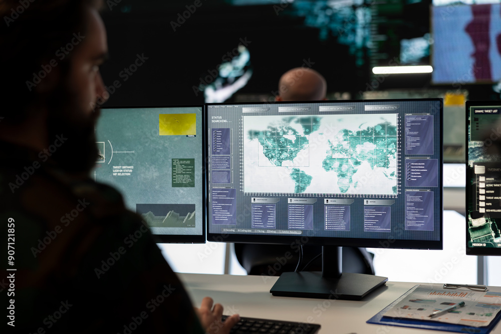 Trooper examines surveillance radar CCTV imagery in control center, monitoring the deployed infantry unit during an ongoing operation. Army conscript works in reconnaissance division. Trooper examines surveillance radar CCTV imagery in control center, monitoring the deployed infantry unit during an ongoing operation. Army conscript works in reconnaissance division.