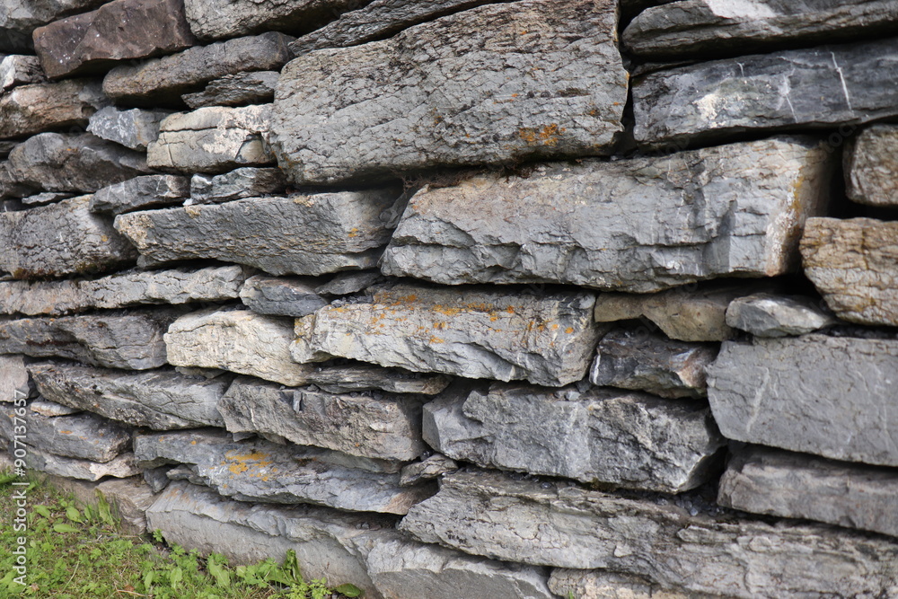 Fototapeta premium Gray stone blocks with soil and plants.