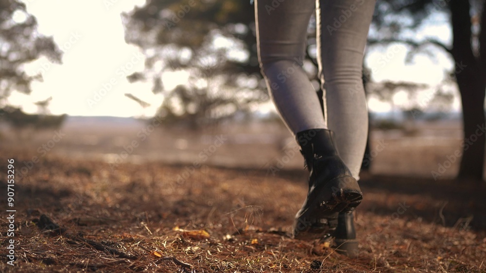 tourist girl walks through the forest. tourist recreation concept. female legs in black boots walk through a bright spring forest with glare of the sun close-up. lifestyle tourist tourist girl walks through the forest. tourist recreation concept. female legs in black boots walk through a bright spring forest with glare of the sun close-up. lifestyle tourist